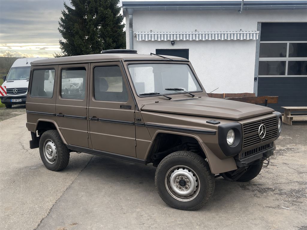 Der Mercedes G von schräg vorn, fertig lackiert in mattem Beige, sauber, vollständig, wie er einmal aussehen soll.